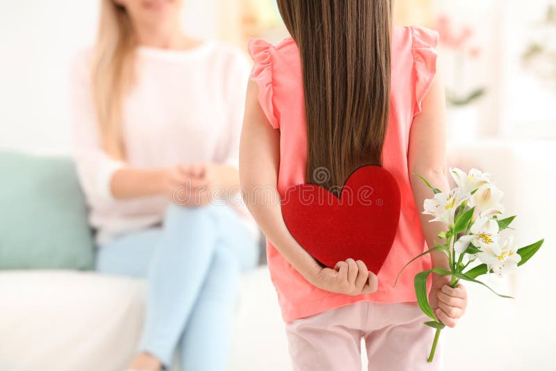 Little girl hiding felt heart and flower for Mother`s Day royalty free stock images Little girl hiding felt heart and flower for Mother`s Day royalty free stock images