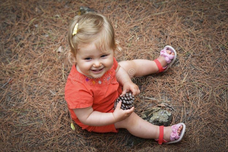 Little girl holding a cone in the woods forest royalty free stock photo Little girl holding a cone in the woods forest royalty free stock photo
