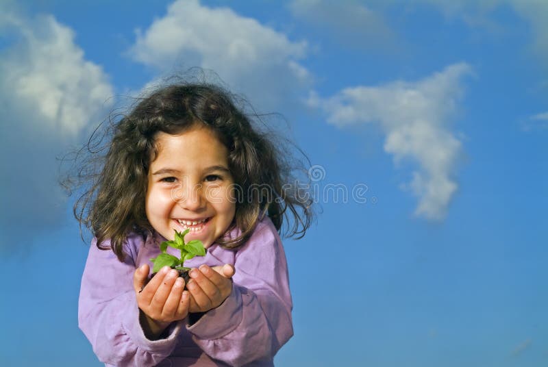 Little girl holding plant