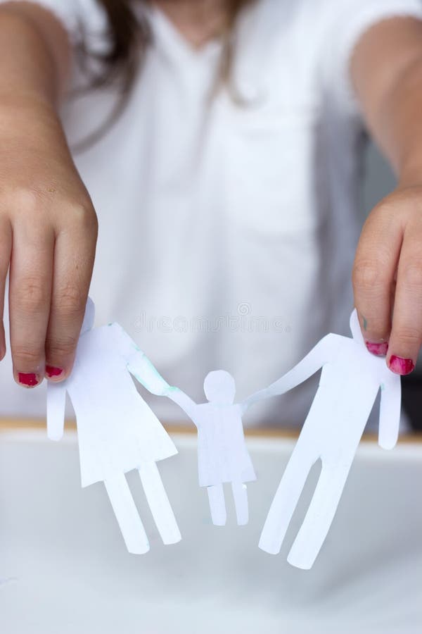 Little girl holds paper chain family; broken family or divorce concept