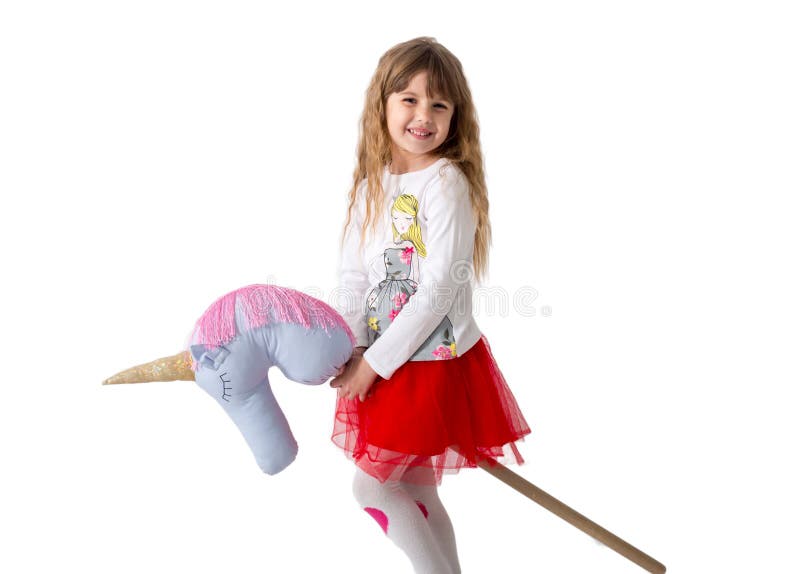 Little girl holds a toy ridge between the legs on a white background. Isolated stock photos Little girl holds a toy ridge between the legs on a white background. Isolated stock photos