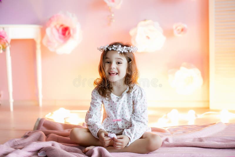 A Little Girl in a Homely Atmosphere Against a Wall with Glowing Lights ...
