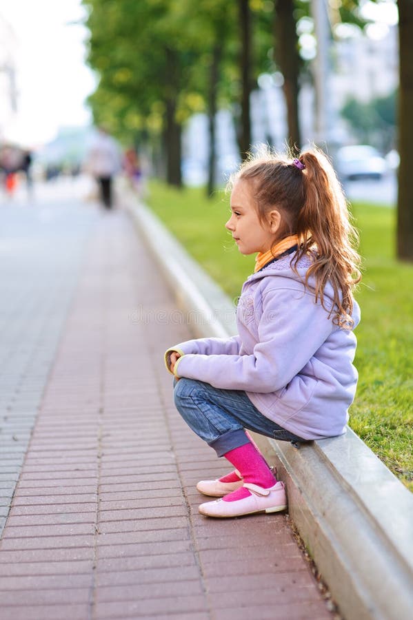 Little Girl in Jacket Sitting on Stock Photo Image of outside, head