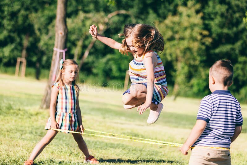 Little girl jumping through the elastic, playing with other children. stock image Little girl jumping through the elastic, playing with other children. stock image
