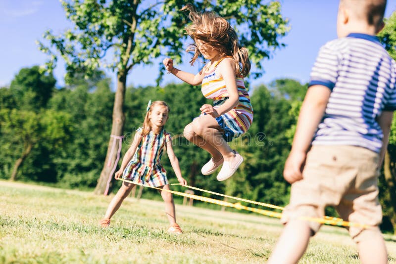 Little girl jumping high through the elastic. Chinese jump rope. Childhood games.