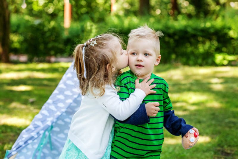 Little girl kisses friend. 2-3 years. Girl and boy. The concept stock image Little girl kisses friend. 2-3 years. Girl and boy. The concept stock image