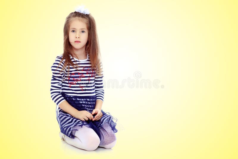 Little girl kneeling on the floor.