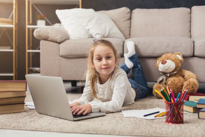 Cute Little Girl Doing Homework on Laptop, Lying on Floor Stock Photo ...