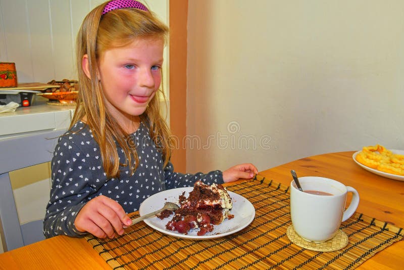 Little girl looking on her birthday cake. Small girl celebrating her six birthday. Little girl is eating cake royalty free stock images Little girl looking on her birthday cake. Small girl celebrating her six birthday. Little girl is eating cake royalty free stock images