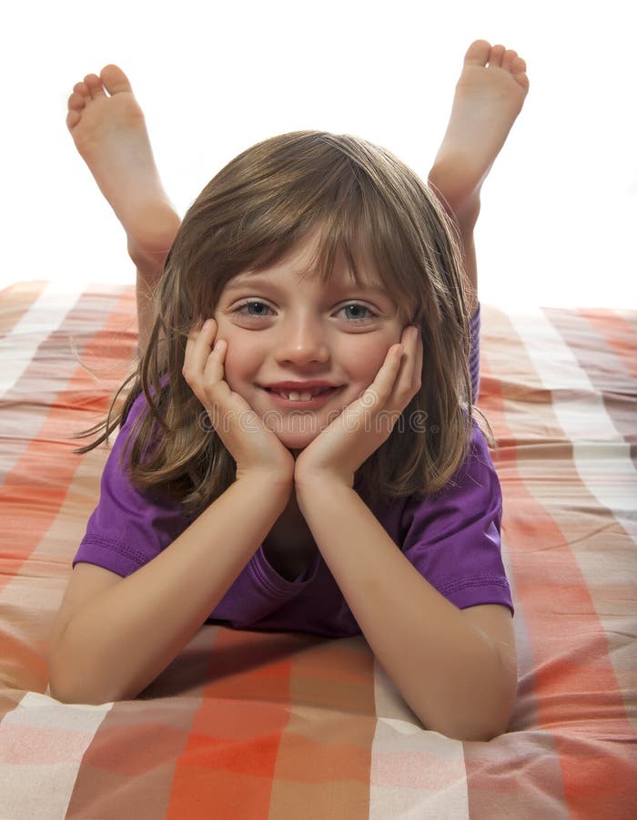 Little girl lying on a bed stock photo. Image of happy 27842244