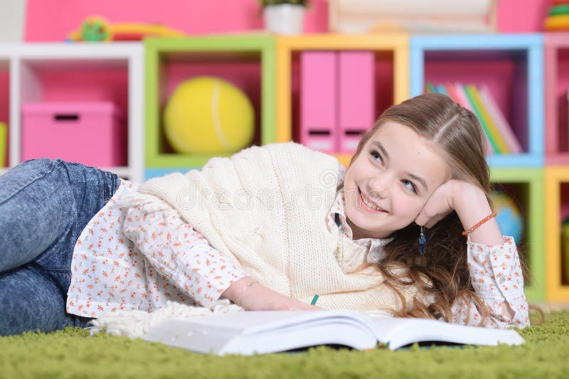 little girl lying on green carpet