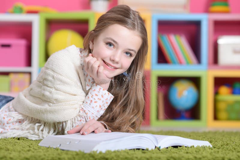 little girl lying on green carpet