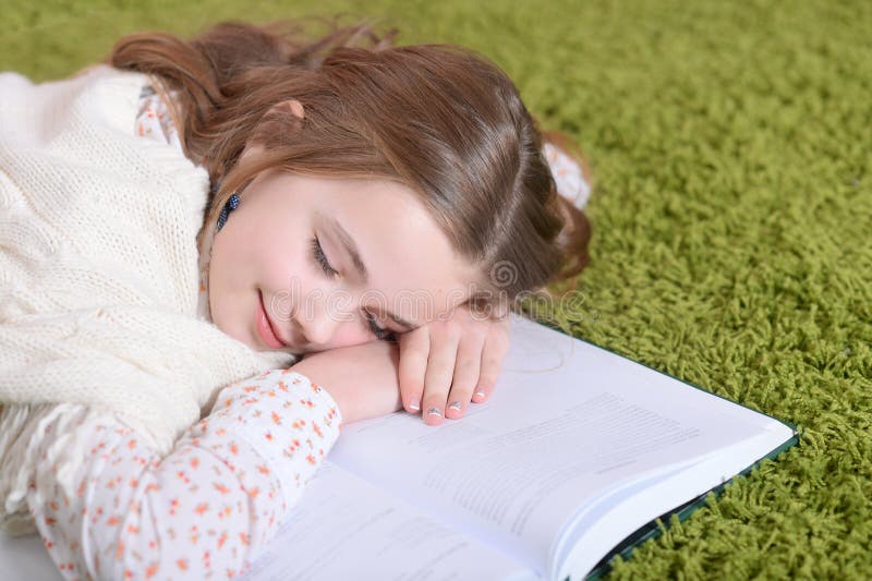 little girl lying on green carpet