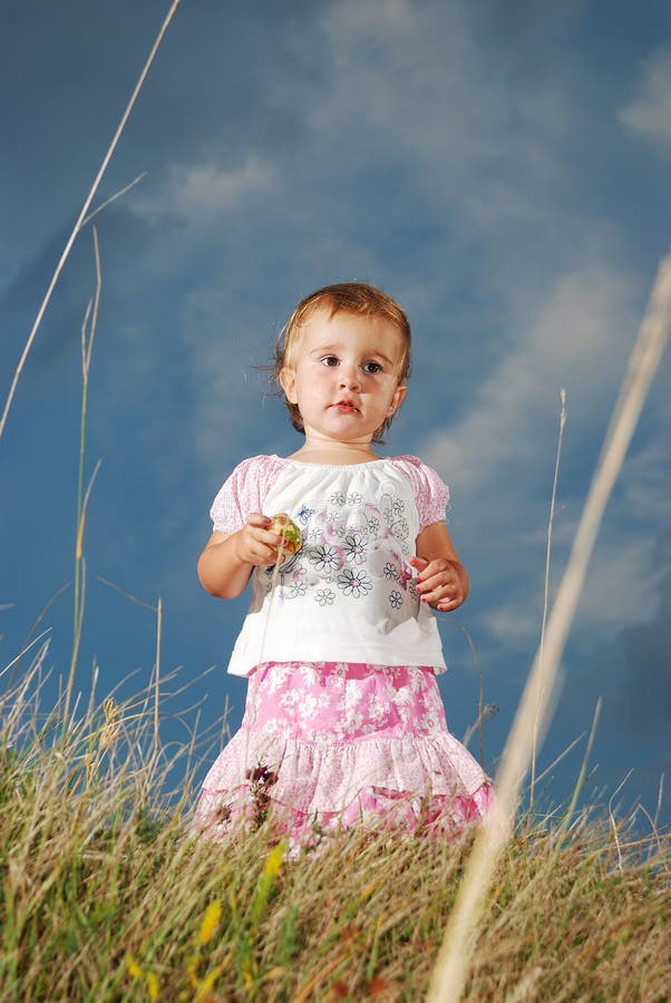 Little girl on meadow before sunset royalty free stock image