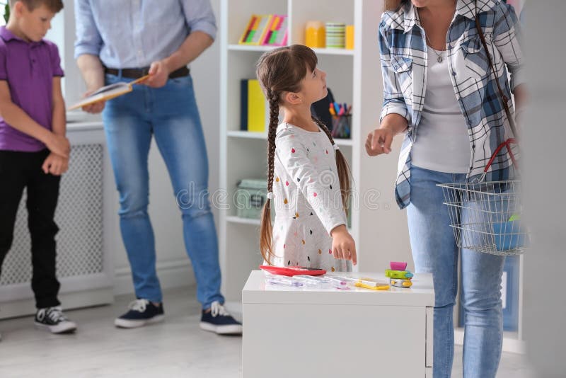 Little girl with mother choosing school stationery stock image Little girl with mother choosing school stationery stock image