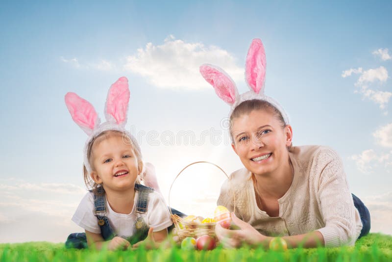 Little girl with mother dressed as the Easter bunny lying on the