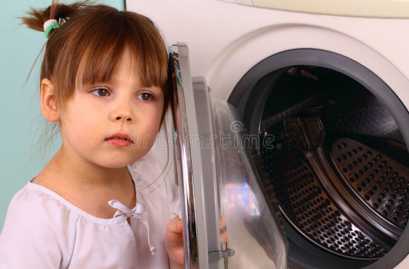 A little girl opens the washing machine royalty free stock photo