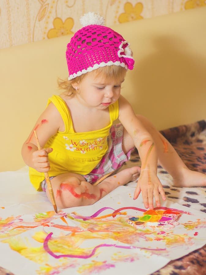 The little girl is painting stock photography