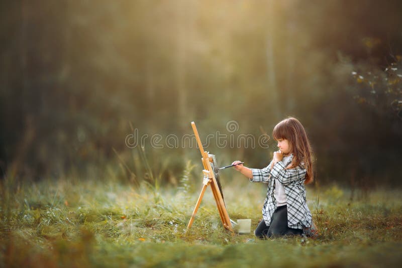 Little girl painting outdoors