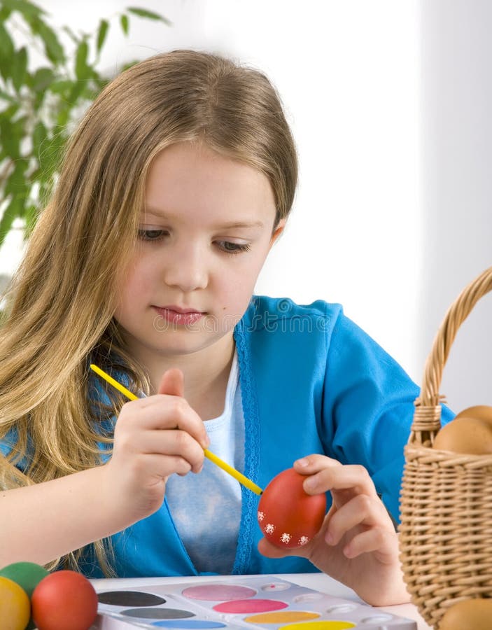 Little girl painting easter eggs