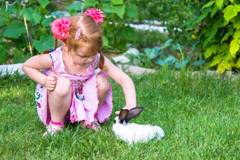 Little girl petting a bunny.