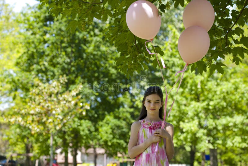 Little girl with pink balllons