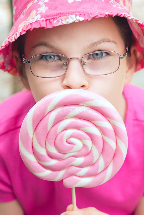 Little girl in a pink hat holding lollipop royalty free stock image Little girl in a pink hat holding lollipop royalty free stock image