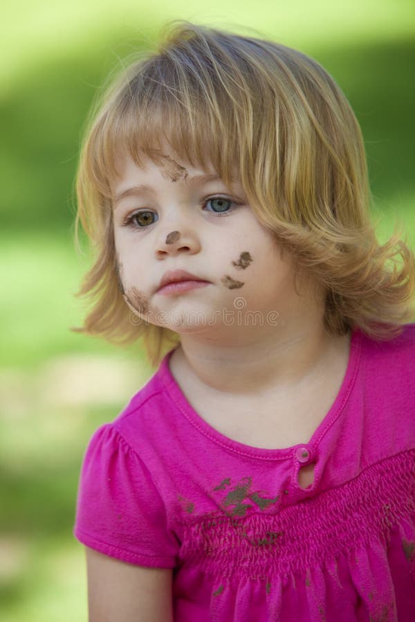 Little girl in pink with muddy face