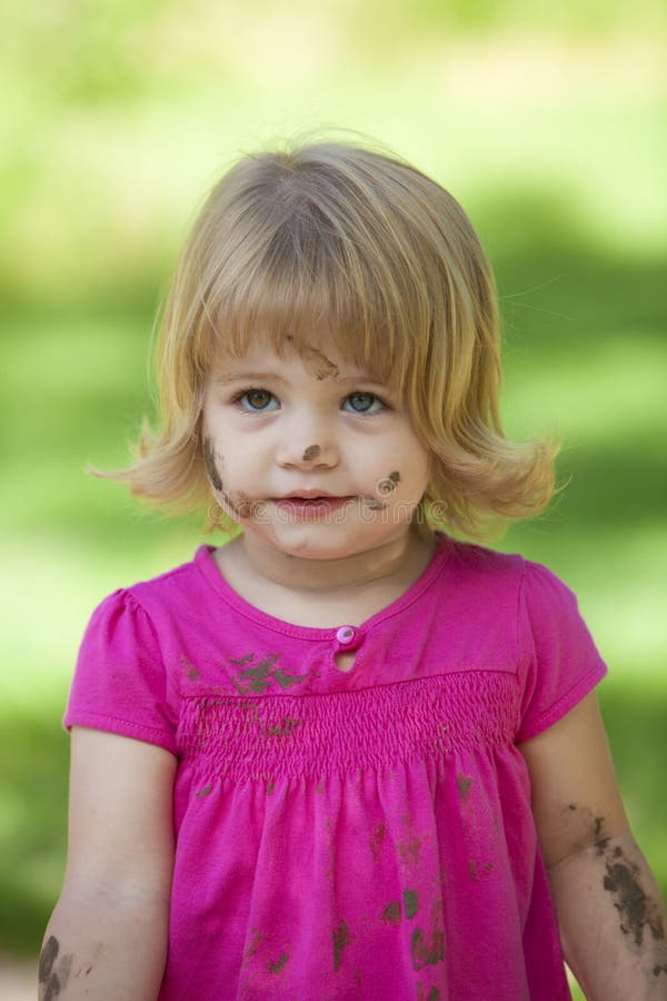 Little girl in pink with muddy face