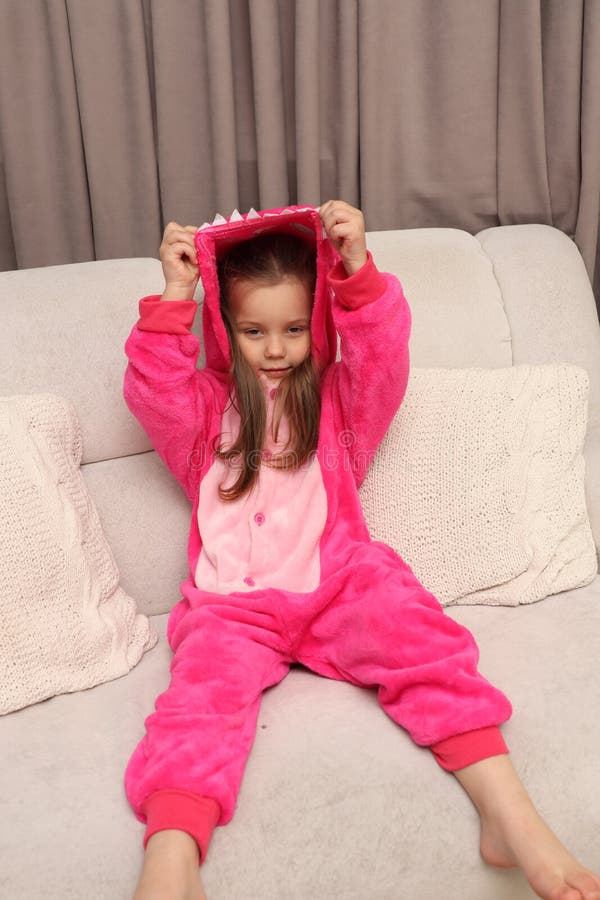 Hide And Seek On The Sofa Little Girl in Pink Pajamas on a White Sofa. the Child Plays Hide and