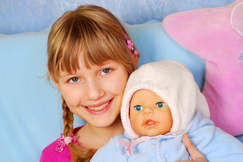 Portrait of sweet little girl playing with the doll in ...