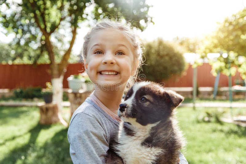 Little girl is playing with a dog. a dog as a gift to children. children`s smile on the nature