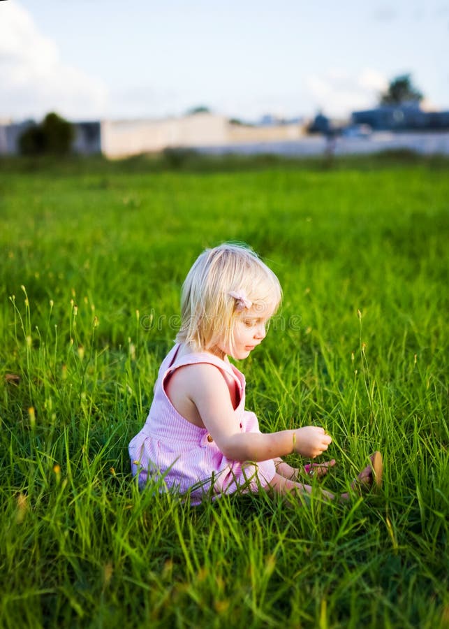 A Little Girl Playing In The Grass Stock Photo Image of child, pink