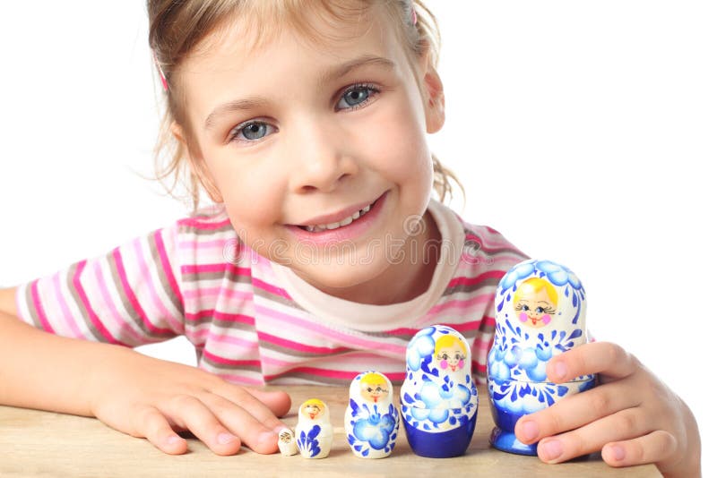 Little girl playing with matryoshka and smiling