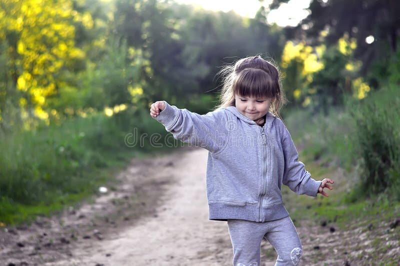 Little girl playing in sunny blooming forest. Toddler child picking flowers. Summer fun for family with children. stock image Little girl playing in sunny blooming forest. Toddler child picking flowers. Summer fun for family with children. stock image