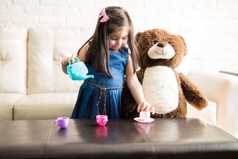 Little girl playing with a tea set