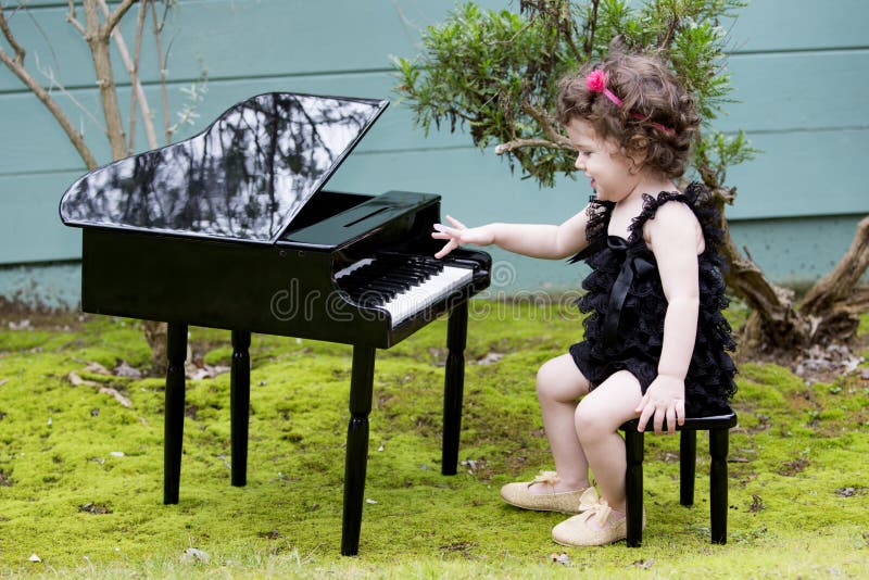 Little girl playing on toy piano