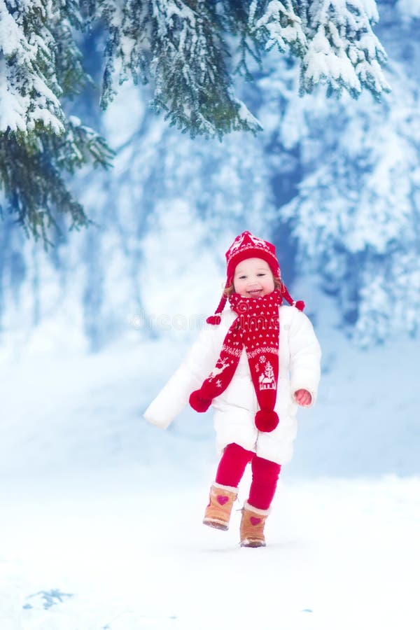 Little girl playing in a winter park