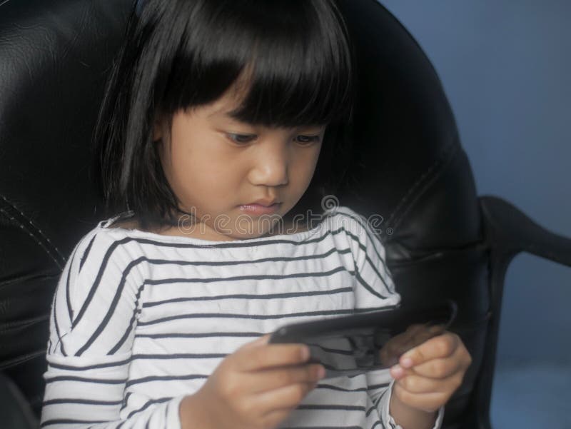 Little Girl Plays with Gadget Smart Phone royalty free stock photos