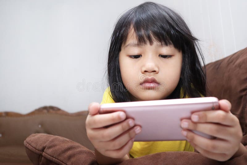 Little Girl Plays with Gadget Smart Phone royalty free stock photography