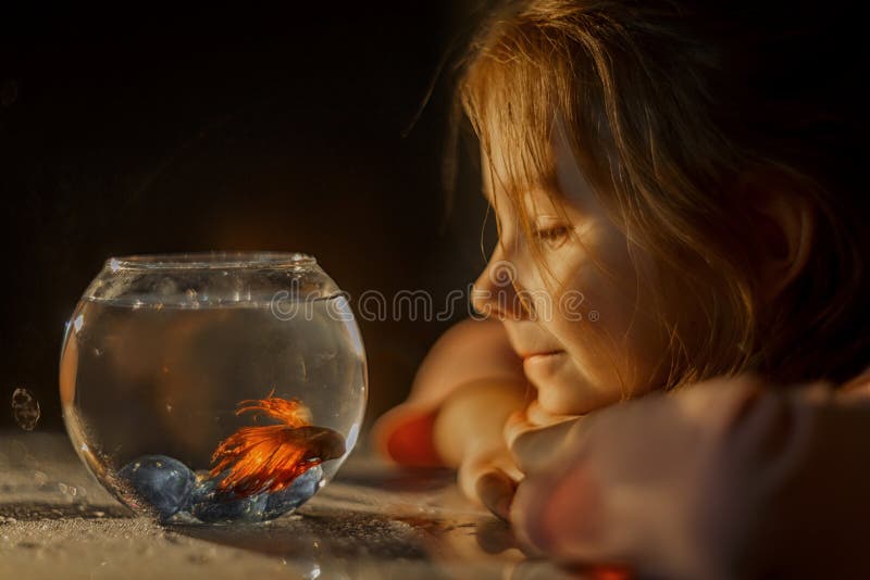 Little girl portrait with fish in round aquarium