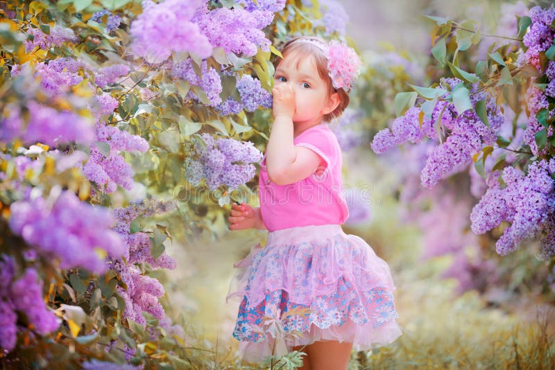 Little girl portrait in a lilac garden stock image Little girl portrait in a lilac garden stock image