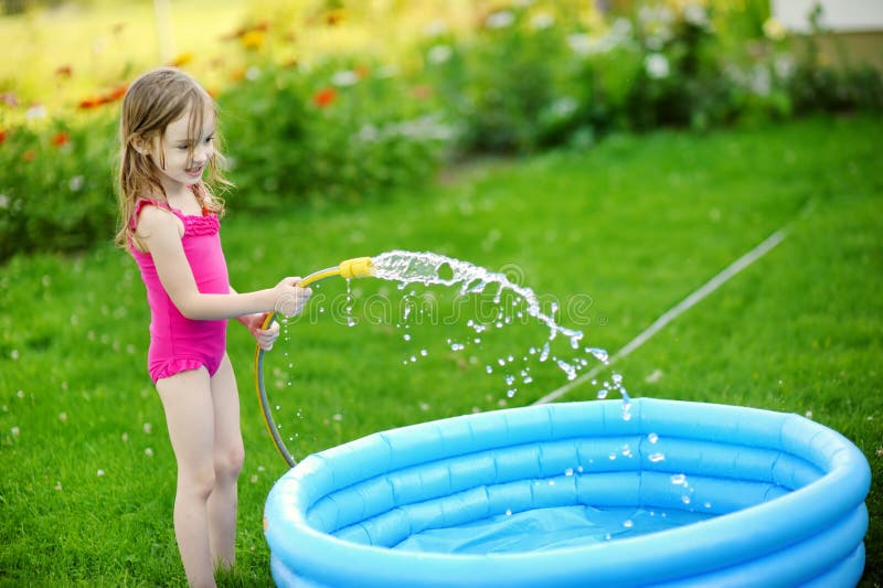 Little girl pouring water into a pool