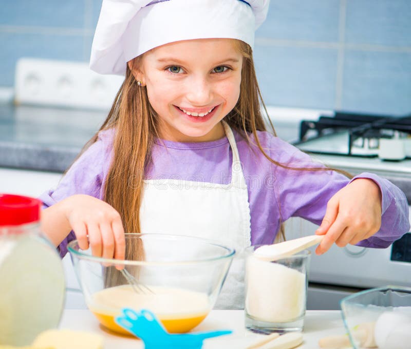 Little girl pours sugar cookie dough