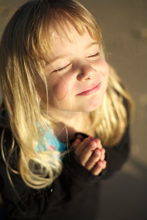 A cute little girl with hands together in prayer. A cute little girl with hands together in prayer.
