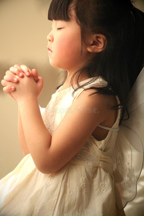 Cute little girl praying in the room