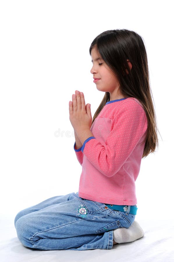Little girl praying on her knees over a white background