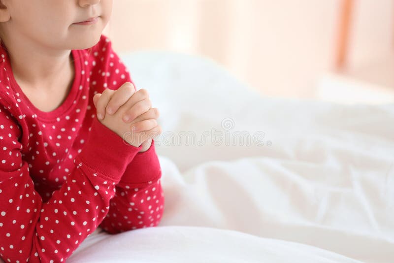 Little girl praying in bedroom