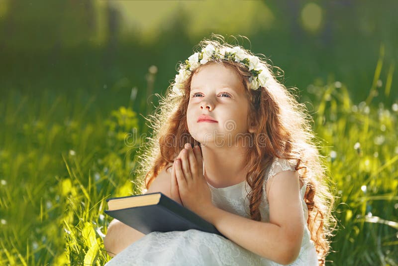 Little girl folded her hand with praying, dreaming in park outdoors. Little girl folded her hand with praying, dreaming in park outdoors.