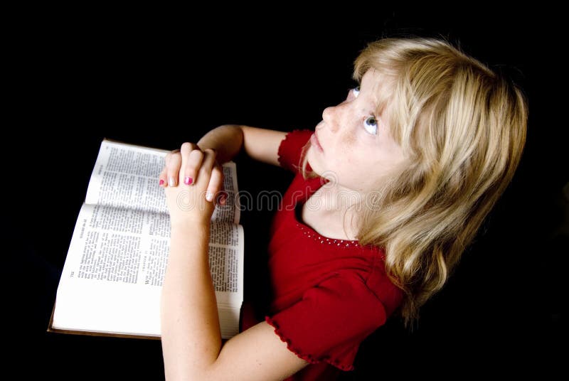 Angelic little girl saying her prayers over an open New Testament. Angelic little girl saying her prayers over an open New Testament.